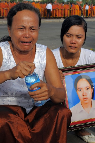 The Cambodian aunt and sister of a vicitim pray for their relative at the Diamond Gate bridge